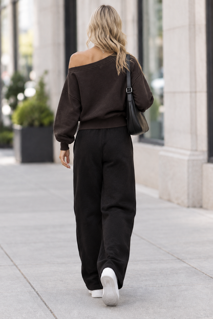 Back view of blonde model wearing sweatshirt on city sidewalk