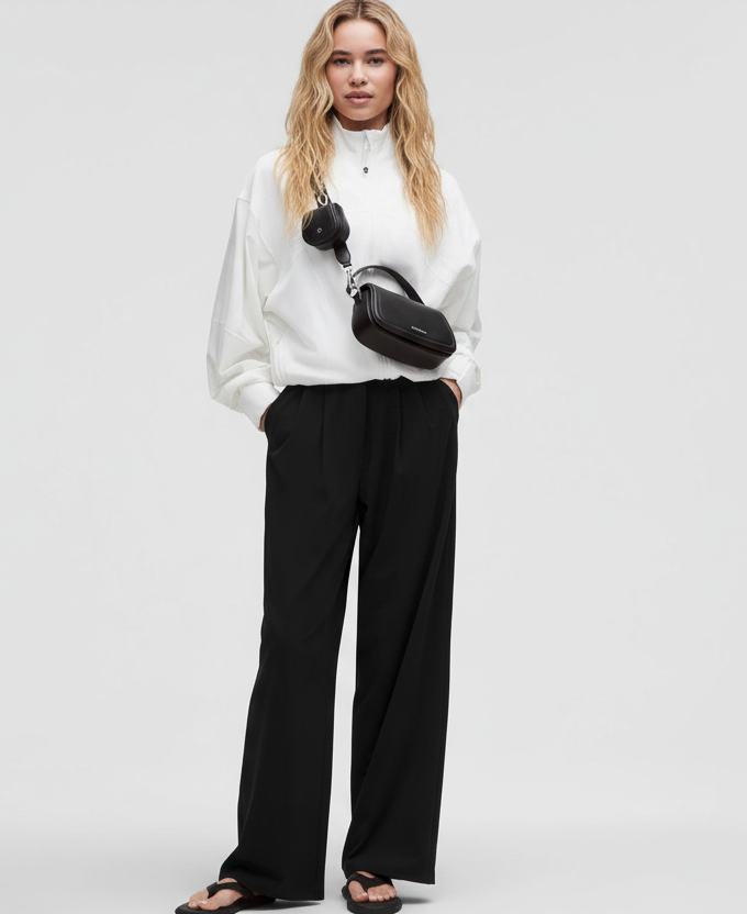 Model with long blonde hair in white top and navy pants - front view