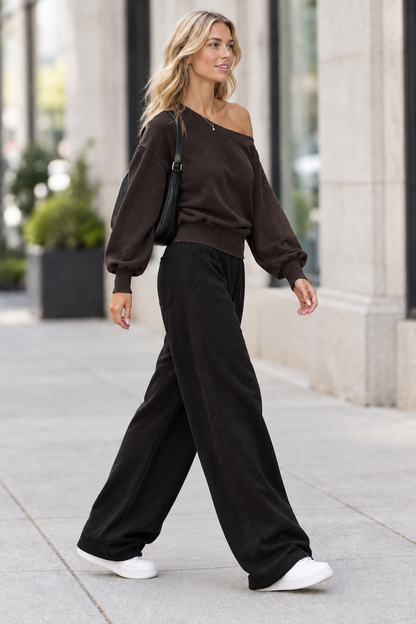 Side view of blonde model wearing sweatshirt on city sidewalk